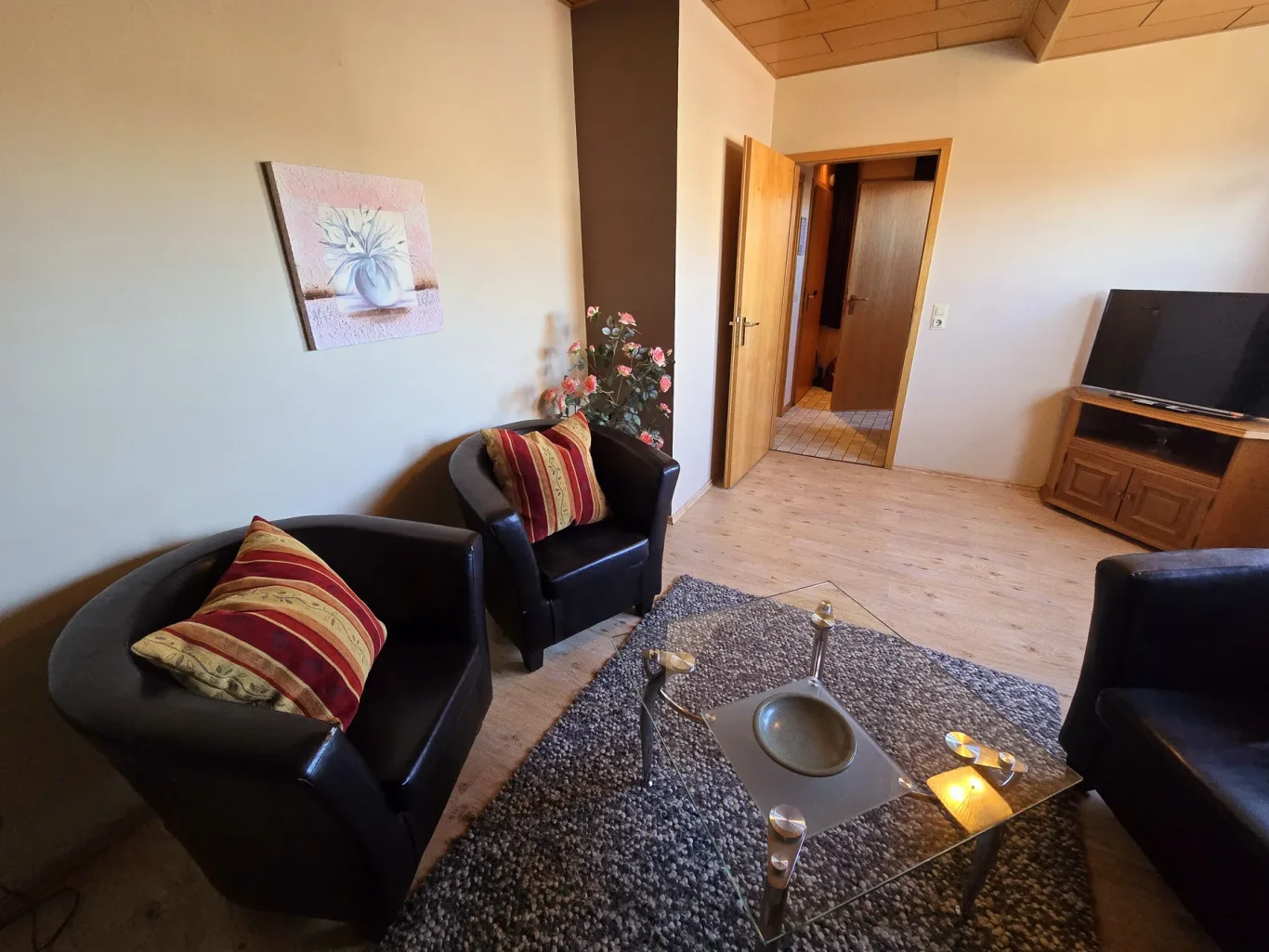 Wohnzimmer Wohnbereich mit Sofa und TV in Ferienwohnung auf Fehmarn